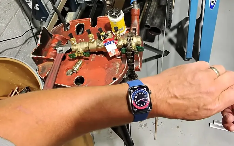 Technician testing ports on a backflow prevention device for commercial plumbing in Laguna Niguel