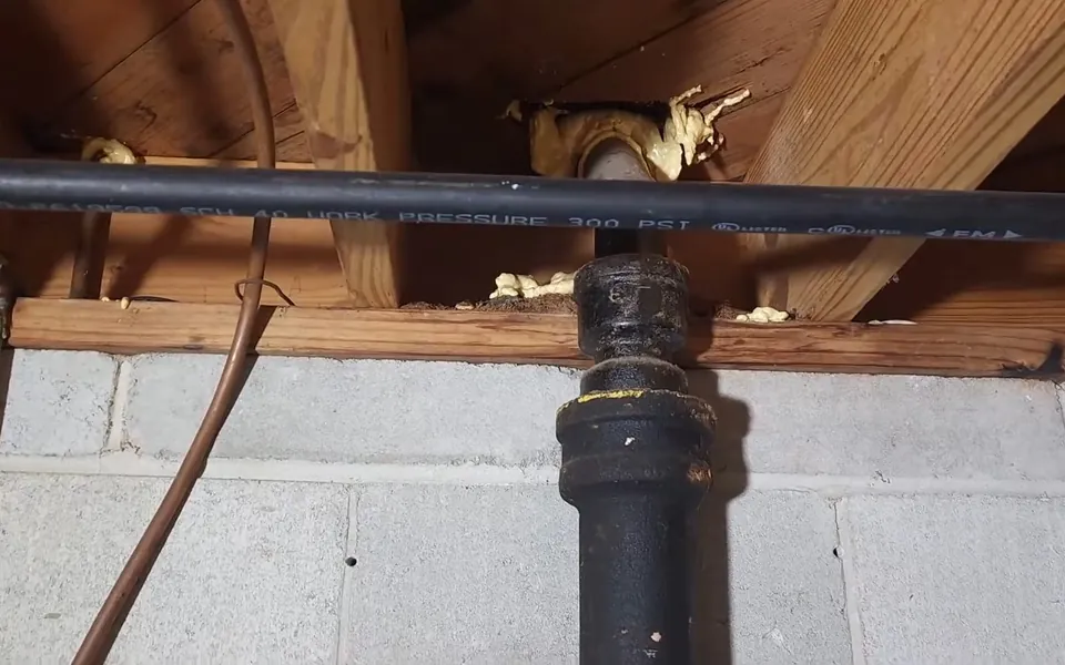 Aged cast iron drain stack with visible fittings for pipe repair replacement in Laguna Niguel