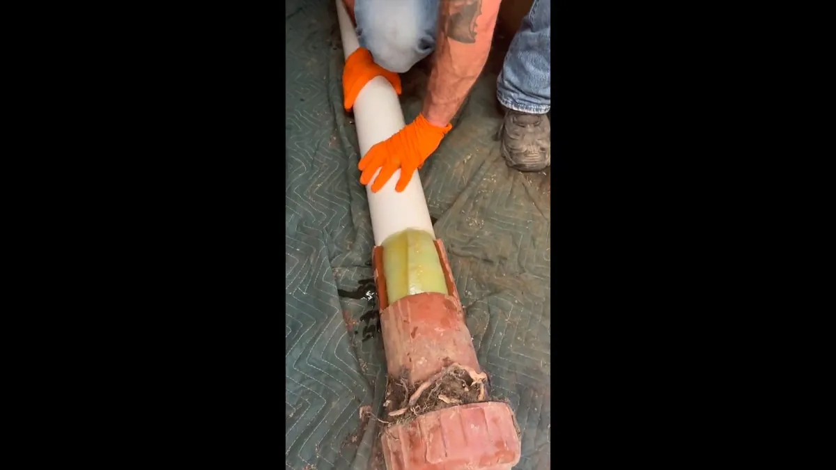 Cured-in-place liner being fed into a damaged pipe for trenchless sewer repair in Laguna Niguel