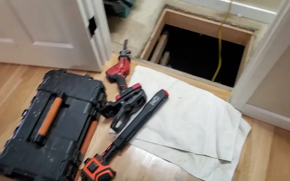Drain inspection equipment beside a crawlspace floor opening for residential plumbing service in San Joaquin Hills, Laguna Niguel