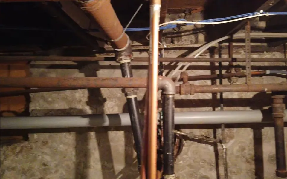 Exposed basement plumbing lines and drain connections for plumbing service consultation in Laguna Niguel
