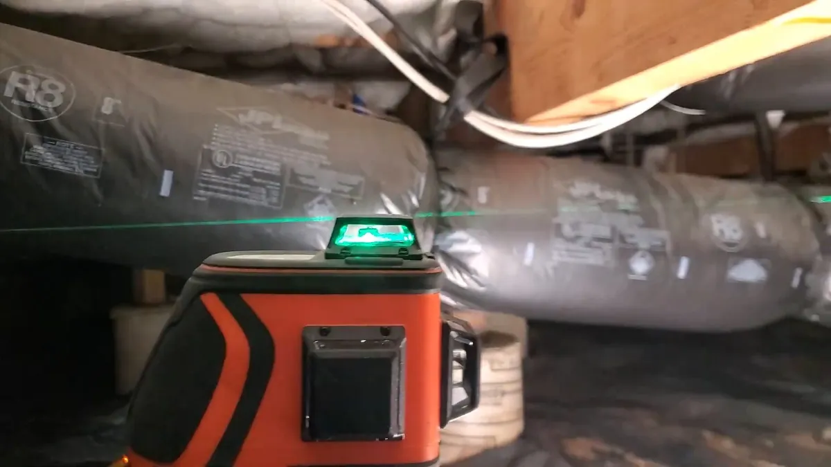 Laser level aligned with a drain pipe installation for sewer line repair in Laguna Niguel