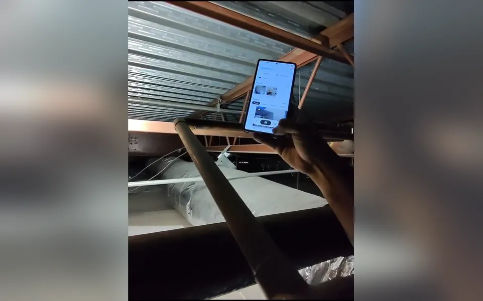Technician using a phone to inspect overhead plumbing for drain cleaning unclogging in Laguna Niguel