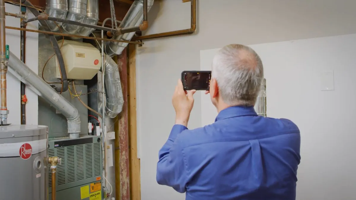 Technician photographing installed water treatment equipment for annual plumbing maintenance in Laguna Niguel