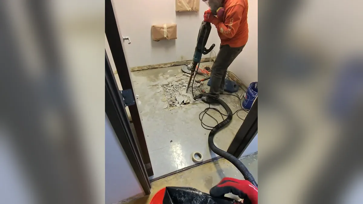 Powered drain cleaning machine positioned on a wet floor for drain cleaning unclogging in Laguna Niguel