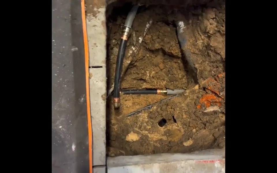 Narrow concrete trench exposing water lines beneath a floor for plumbing emergency what to do in Laguna Niguel