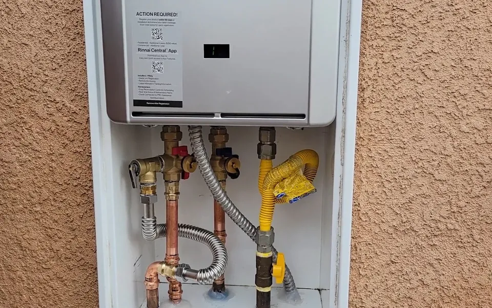 Wall-mounted tankless water heater with visible service connections for water heater repair in Laguna Niguel