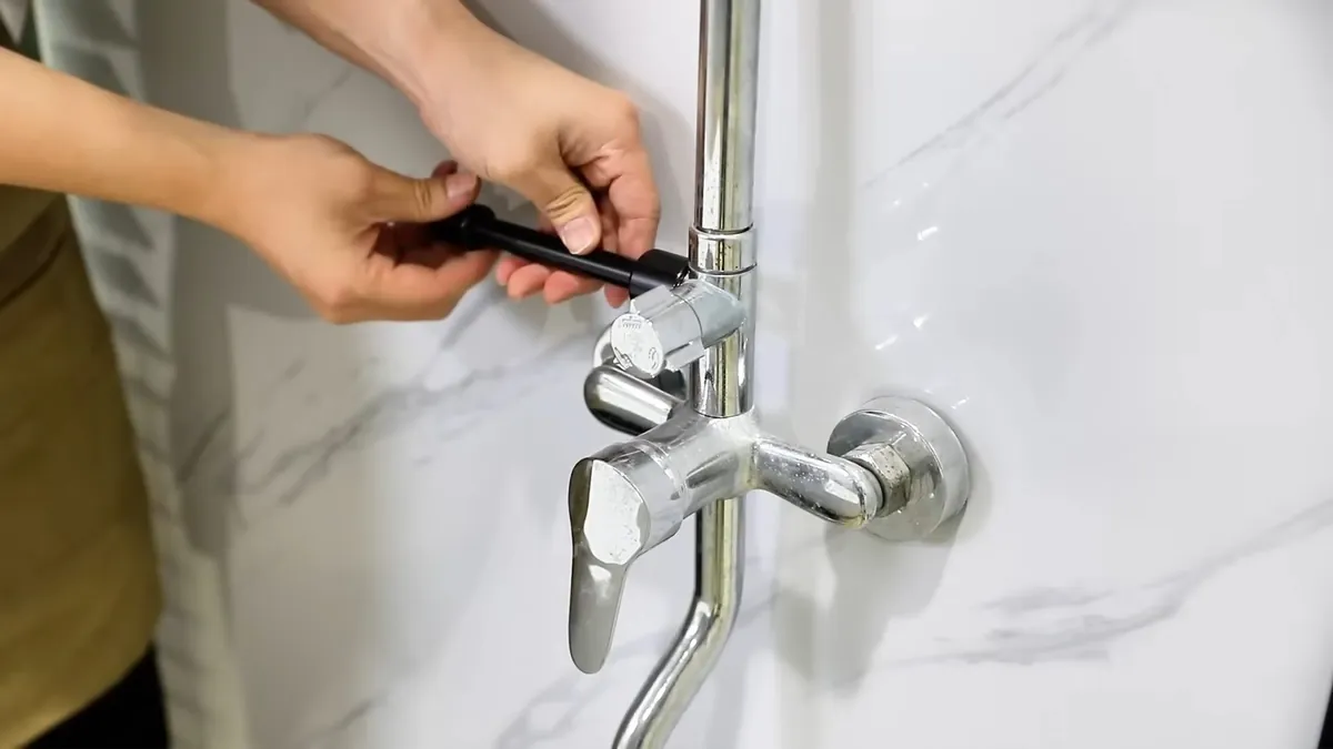 Technician adjusting a wall-mounted tub and shower valve for shower tub repair in Laguna Niguel